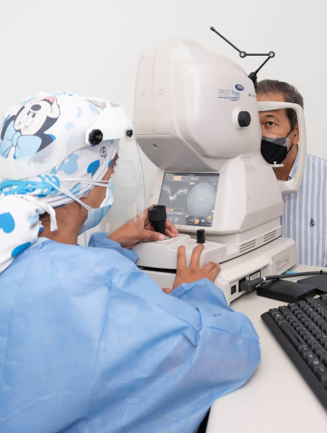 En un ambiente de consultorio médico, se ve a una profesional de la salud examinando los ojos de un paciente, usando un equipo médico.